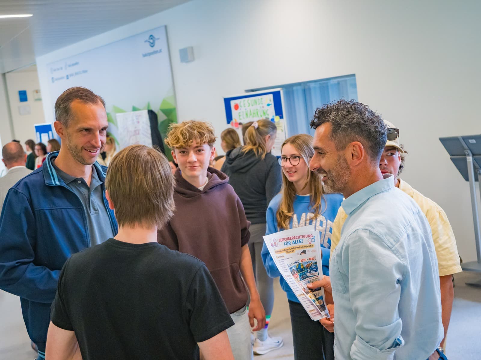Schüler:innen zeigen ihre Arbeitsergebnisse an ihrem Ausstellungstisch